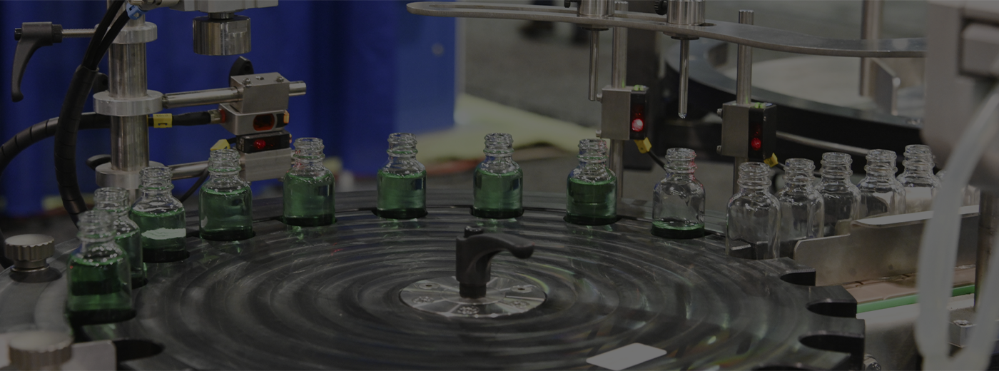 Bottled of green liquid enter a conveyor belt